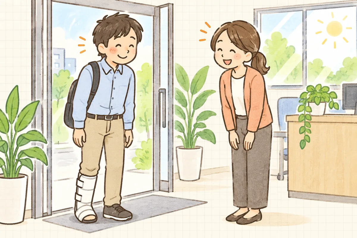 手続きの見通しが立ち、ケガから回復して出勤してきた従業員を事務所で笑顔で迎えている中小企業のひとり労務担当者